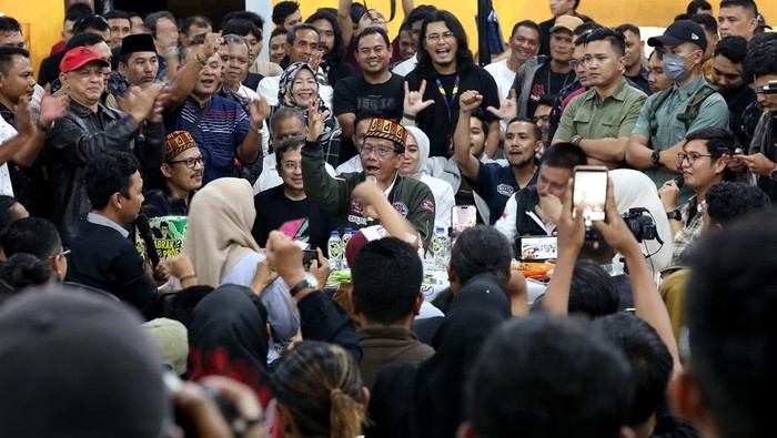 Calon wakil presiden nomor urut 3 Mahfud MD (tengah) 
memakai kopiah khas Aceh saat menghadiri kampanye dan diskusi rakyat Tabrak Prof di warkop MZ, Banda Aceh, Aceh, Rabu (31/1/2024) malam. Cawapres yang berpasangan dengan capres Ganjar Pranowo itu menyatakan segera menyerahkan surat pengunduran diri sebagai Menko Polhukam kepada Presiden Joko Widodo setelah kembali dari kunjungannya di Aceh. ANTARA FOTO/Irwansyah Putra/aww.