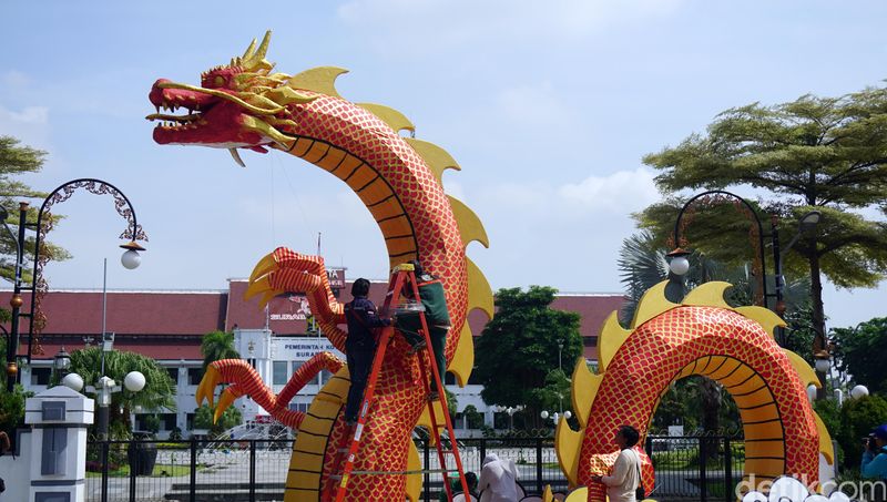 Sejumlah petugas dekorasi Dinas Lingkungan Hidup (DLH) Kota Surabaya memasang ornamen naga dengan tinggi 5 meter dan pajang 20 meter di Balaikota Surabaya menyambut perayaan Imlek, Kamis (1/4/2024).