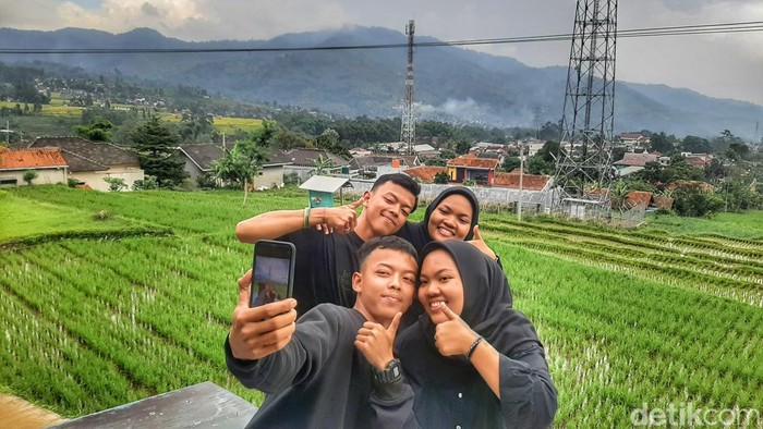Pasangan kembar saat berswafoto di kediamannya di Kampung Palasari, Desa Cikalong, Kecamatan Cimaung, Kabupaten Bandung, Kamis (1/2/2024).