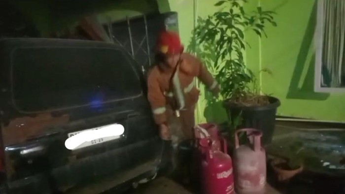 Petugas Damkar Kota Jambi melakukan proses pendinginan elpiji meledak di pangakalan gas.