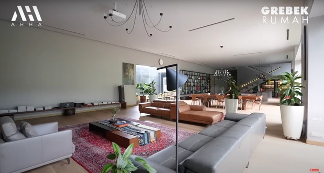 Tampak begitu luas dan estetik, begini potret ruang tamu yang juga bisa dijadikan ruang keluarga di rumah baru Tompi. Berlantai kayu, ruangan tersebut tampak nyaman dan asri dengan dihiasi beberapa tumbuhan hijau. Foto: YouTube/AH