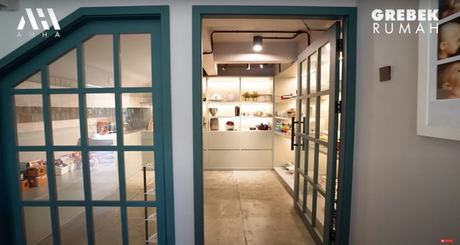 Di dekat dapur, Tompi juga menyiapkan ruangan khusus untuk meletakkan perabotan dapur sekaligus panci koleksi istrinya. Seperti etalase mal, barang-barang di ruangan tersebut tampak tertata dengan rapi. Foto: YouTube/AH