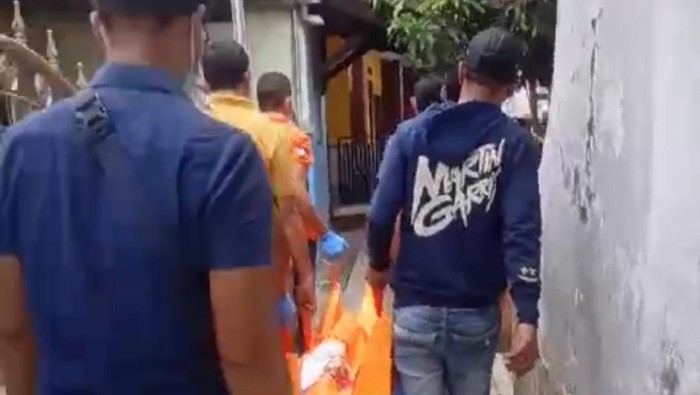 Tangkapan layar video pelaku SN saat ikut menggotong kantung mayat waria yang tewas di kamar kos