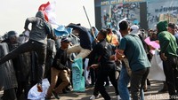 Massa berusaha membongkar barikade petugas.