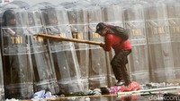 Petugas bertameng membentuk barikade untuk mengadang massa.
