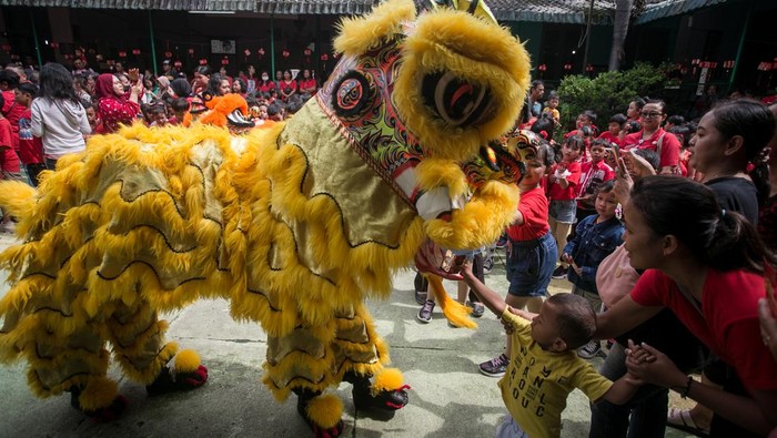 Siswa memberi angpao kepada barongsai usai beratraksi menghibur siswa di SD Warga, Solo, Jawa Tengah, Jumat (2/2/2024). Atraksi barongsai tersebut untuk memperkenalkan kesenian dan budaya Tionghoa kepada para siswa serta menyambut Tahun Baru Imlek. ANTARA FOTO/Mohammad Ayudha/tom.