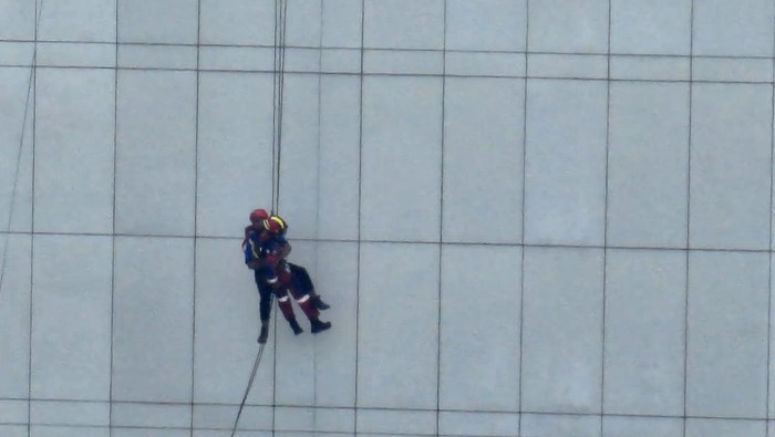 Damkar evakuasi dua pekerja yang terjebak di gedung tinggi Jaktim gara-gara tali gondola putus.