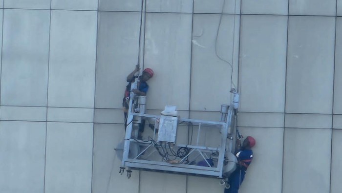 Damkar evakuasi dua pekerja yang terjebak di gedung tinggi Jaktim gara-gara tali gondola putus.
