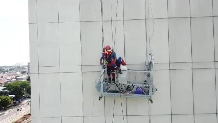 Damkar evakuasi dua pekerja yang terjebak di gedung tinggi Jaktim gara-gara tali gondola putus.