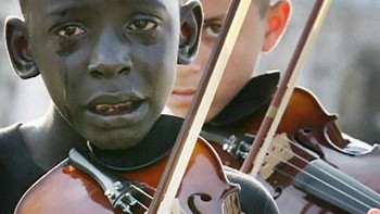 Anak ini menangis ketika bermain biola saat mengiringi kepergian gurunya yang telah meninggal dunia. Foto: Brightside