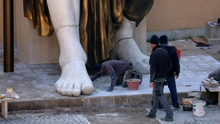 Patung Raksasa Kaisar Romawi Konstantinus Agung Hiasi Taman di Roma An expert works on a reconstruction of the giant statue Colossus of Constantine, Roman emperor Constantine the Great, in Rome, Italy, February 1, 2024. The statue, reconstructed in full 12-meter height with 3D printing technology, will go on public display on February 6, 2024. REUTERS/Remo Casilli