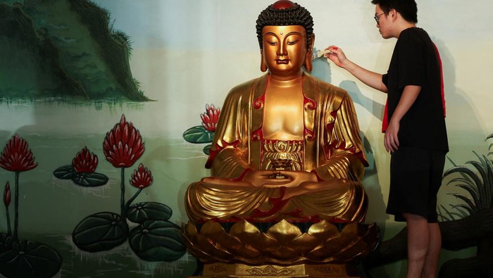 A worshiper washes a religious statue ahead of the Chinese Lunar New Year celebration at the Amurva Bhumi temple in Jakarta, Indonesia, February 2, 2024. REUTERS/Ajeng Dinar Ulfiana