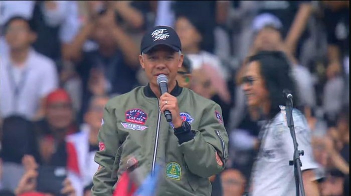 Ganjar Pranowo tiba mengenakan jaket bomber warna hijau dan topi warna hitam, Sabtu (3/2/2024). Ganjar tiba langsung naik ke panggung dan bernyanyi bersama Slank.