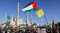 Massa membentangkan poster dan mengibarkan bendera Palestina.