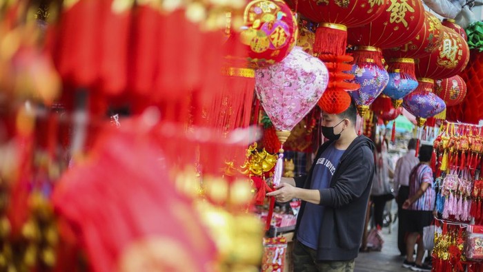 Seorang anak berjalan di antara pernak pernik Imlek di Jakarta, Jumat (2/2/2024). Pernak-pernik Imlek seperti angpau, hiasan dinding, barongsai mini, lampion, pohon dan aksesoris lainnya tersebut dijual seharga Rp10.000 hingga Rp5 juta. ANTARA FOTO/Rivan Awal Lingga/Spt.