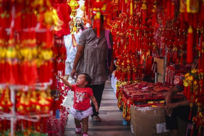 Seorang anak berjalan di antara pernak pernik Imlek di Jakarta, Jumat (2/2/2024). Pernak-pernik Imlek seperti angpau, hiasan dinding, barongsai mini, lampion, pohon dan aksesoris lainnya tersebut dijual seharga Rp10.000 hingga Rp5 juta. ANTARA FOTO/Rivan Awal Lingga/Spt.