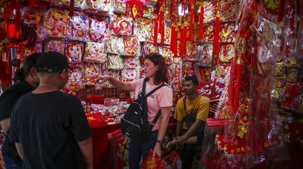 Seorang anak berjalan di antara pernak pernik Imlek di Jakarta, Jumat (2/2/2024). Pernak-pernik Imlek seperti angpau, hiasan dinding, barongsai mini, lampion, pohon dan aksesoris lainnya tersebut dijual seharga Rp10.000 hingga Rp5 juta. ANTARA FOTO/Rivan Awal Lingga/Spt.