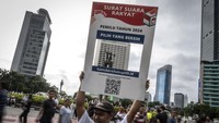 Massa dari Transparency International Indonesia melakukan aksi saat berlangsungnya Hari Bebas Kendaraan Bermotor (HBKB) di kawasan Bundaran HI, Jakarta, Minggu (4/2/2024).