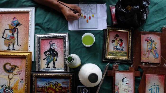 Perajin membuat suvenir kaca lukis saat pameran Solo Art Market di kawasan wisata Ngarsopuro, Solo, Jawa Tengah, Minggu (4/2/2024). Suvenir kaca lukis tersebut dijual dengan harga Rp80 ribu - Rp500 ribu tergantung ukuran dan kerumitan gambar. ANTARAFOTO/Maulana Surya/Spt.