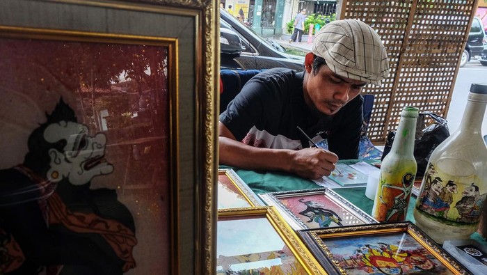 Perajin membuat suvenir kaca lukis saat pameran Solo Art Market di kawasan wisata Ngarsopuro, Solo, Jawa Tengah, Minggu (4/2/2024). Suvenir kaca lukis tersebut dijual dengan harga Rp80 ribu - Rp500 ribu tergantung ukuran dan kerumitan gambar. ANTARAFOTO/Maulana Surya/Spt.