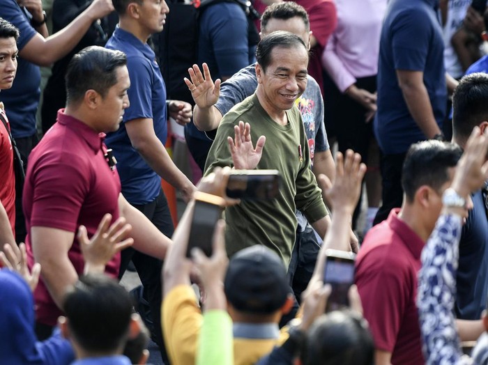Presiden Joko Widodo (kanan) menyapa warga saat berjalan kaki di Lapangan Gasibu, Bandung, Jawa Barat, Minggu (4/2/2024).  Presiden Joko Widodo ditemani keluarga melakukan jalan santai di tempat itu. ANTARA FOTO/Hafidz Mubarak A/Spt.