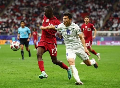 Soccer Football - AFC Asian Cup - Quarter Final - Qatar v Uzbekistan - Al Bayt Stadium, Al Khor, Qatar - February 3, 2024 Uzbekistans Azizbek Turgunboyev in action with Qatars Almoez Ali REUTERS/Molly Darlington