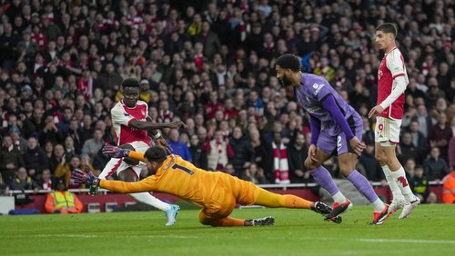 Arsenals Bukayo Saka, left, scores his sides first goal during the English Premier League soccer match between Arsenal and Liverpool at Emirates Stadium in London,, Sunday, Feb. 4, 2024. (AP Photo/Kin Cheung)