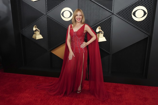 Red on red. Kylie Minogue menyatu dengan karpet merah dengan gaun Dolce & Gabbana pilihannya. Efek drama dari ekor dan sayap yang menjuntai tetap membuat penampilan ikon pop ini memukau. (Foto: Jordan Strauss/Invision/AP)