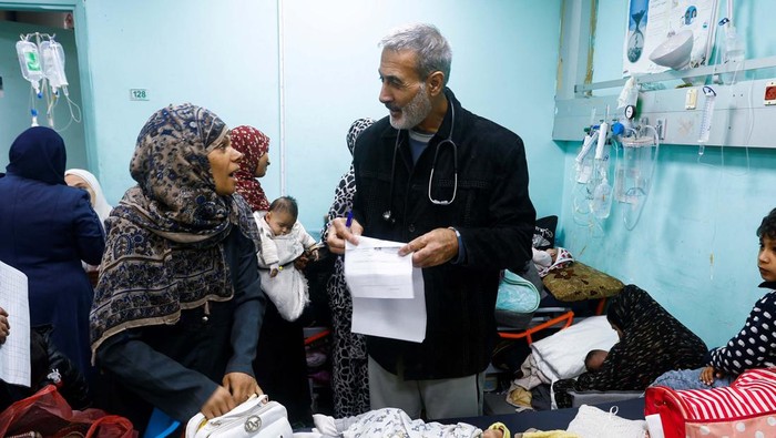 Palestinian doctor Said Abdulrahman Marouf, who was detained by Israel for 45 days and released on Thursday, February 1, embraces a person at Abu Yousef Al-Najjar Hospital in Rafah, in the southern Gaza Strip February 2, 2024. REUTERS/Ibraheem Abu Mustafa