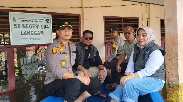 Foto: Polisi hingga Bawaslu saat cek TPS terendam banjir. (dok Polsek Langgam).