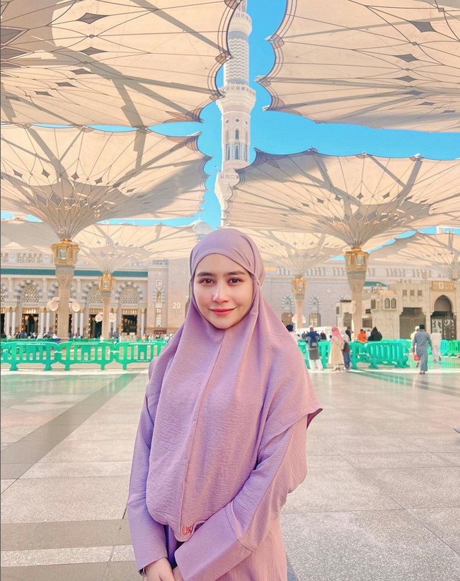 Pesinetron Ganteng-Ganteng Srigala ini terlihat menggunakan setelan hijab dan gamis dari brand Vanilla Hijab saat berpose di bawah payung Masjid Nabawi, Madinah. Foto: Dok. Instagram @prillylatuconsina96.