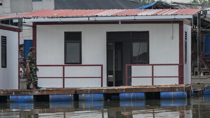 Anggota TNI melihat rumah apung di Blok Empang, Kecamatan Penjaringan, Jakarta, Senin (5/2/2024). Kementerian Pertahanan (Kemhan) bersama Universitas Pertahanan membangun enam unit rumah apung, 12 rumah panggung untuk 18 Kepala Keluarga atau 80 jiwa dan penataan ruang terbuka hijau serta fasilitas umum seperti Desalinasi mengubah air laut menjadi air tawar yang dapat digunakan masyarakat setempat. ANTARA FOTO/Bayu Pratama S/rwa.