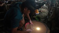 Pekerja tambang membersihkan pasir (ampas) saat proses pengolahan emas di lokasi Pertambangan Rakyat, Desa Anggai, Pulau Obi, Kabupaten Halmahera Selatan, Maluku Utara, Minggu (4/2/2024).