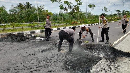 Polisi bersihkan sisa pembakaran ban untuk blokade jalan Bypass BIL-Mandalika di Dusun Kadek, Desa Segala Anyar, Kecamatan Pujut, Lombok Tengah.
