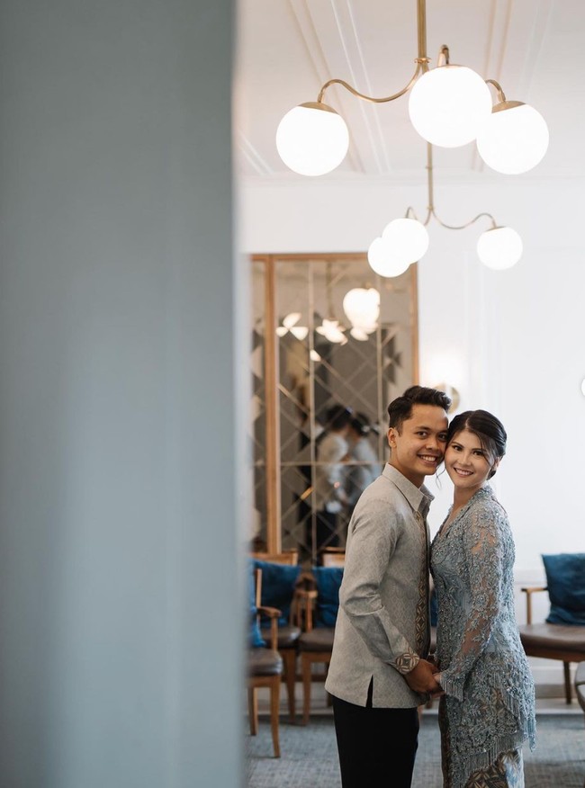 Kebaya kutu baru yang dikenakan oleh Mitzi itu memiliki detail double layer di bagian pinggul dan fringe. Kebaya tersebut dipadukan dengan batik tulis latar motif kawung warna indigo. Motif kawung yang sama dibordir sebagai highlight kemeja yang dikenakan Anthony. Foto: Instagram/@mitziabigail