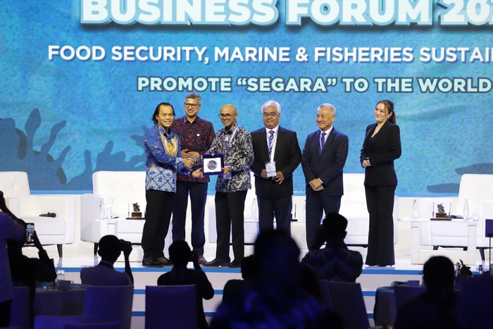 Asisten Khusus Menteri Kelautan dan Perikanan Bidang Media dan Komunikasi Publik, Doni Ismanto menyerahkan buku Perjalanan 25 Tahun Menata Segara kepada Direktur Pengembangan Bisnis dan Pengendalian ID Food Dirgayuza Setiawan, dalam acara Indonesia Marine and Fishries Business Forum (IMFBF) 2024 di Jakarta, Senin (5/5/2024).