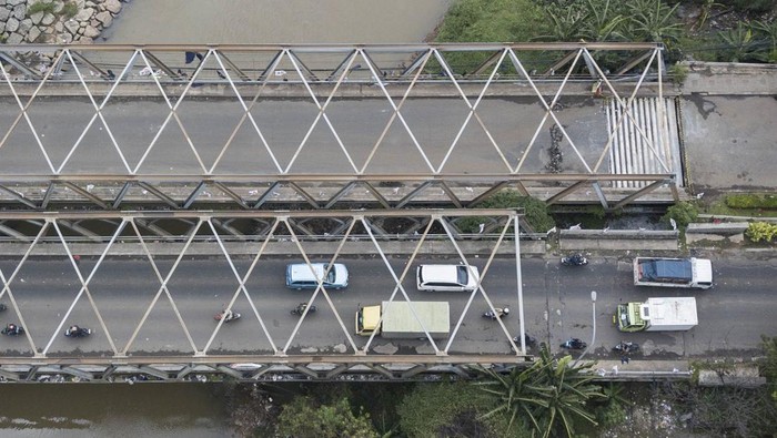 Foto udara sejumlah kendaraan melintas disamping Jembatan Cipendawa yang ditutup karena jalan amblas di Jatiasih, Bekasi, Jawa Barat, Selasa (6/2/2024). Menurut keterangan Dinas Bina Marga dan Sumber Daya Air (BMSDA) satu jembatan yang amblas ditutup sementara akibat puluhan baut yang menopang konstruksi jembatan hilang sehingga menyebabkan penurunan 5-10 centimeter. ANTARA FOTO/ Fakhri Hermansyah/foc.