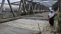 Seorang pejalan kaki melintas di Jembatan Cipendawa yang jalannya amblas akibat baut konstuksi jembatan yang dicuri di Jatiasih, Bekasi, Jawa Barat, Selasa (6/2/2024).