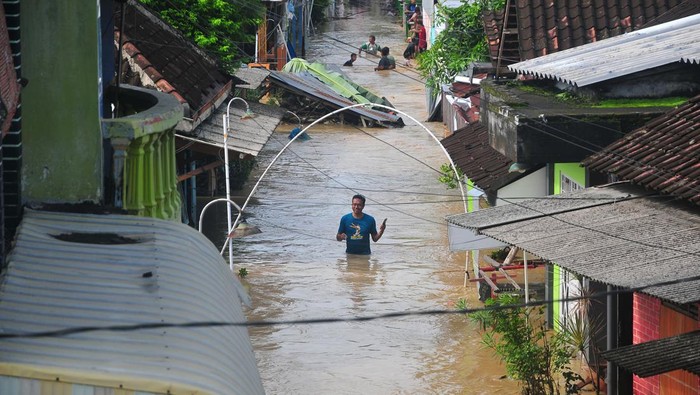 Warga menyaksikan jalan Gubug-Semarang yang ambrol akibat diterjang banjir di Desa Gubug, Gubug, Grobogan, Jawa Tengah, Selasa (6/2/2024). Banjir akibat hujan deras serta jebolnya beberapa tanggul sungai Tuntang itu menyebabkan jalan penghubung Purwodadi-Semarang itu lumpuh dan arus lalu-lintas dialihkan serta ribuan rumah terendam di 11 Kecamatan. ANTARA FOTO/Yusuf Nugroho/foc.
