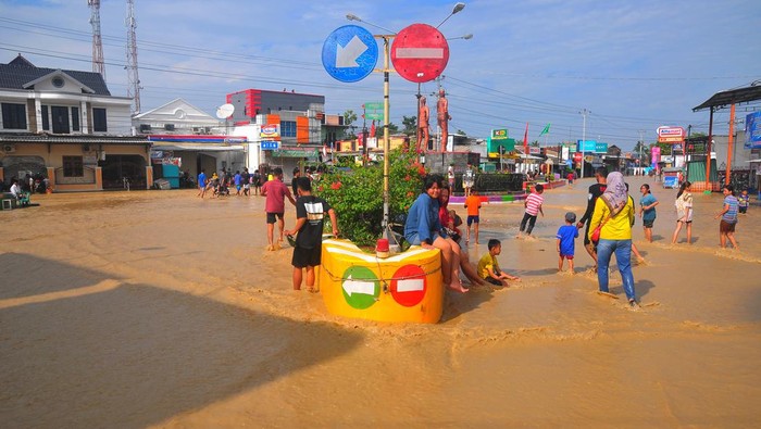 Warga menyaksikan jalan Gubug-Semarang yang ambrol akibat diterjang banjir di Desa Gubug, Gubug, Grobogan, Jawa Tengah, Selasa (6/2/2024). Banjir akibat hujan deras serta jebolnya beberapa tanggul sungai Tuntang itu menyebabkan jalan penghubung Purwodadi-Semarang itu lumpuh dan arus lalu-lintas dialihkan serta ribuan rumah terendam di 11 Kecamatan. ANTARA FOTO/Yusuf Nugroho/foc.