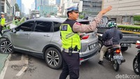Petugas polisi mengatur lalu lintas di lokasi kecelakaan tunggal Honda CRV tabrak beton pembatas jalan.