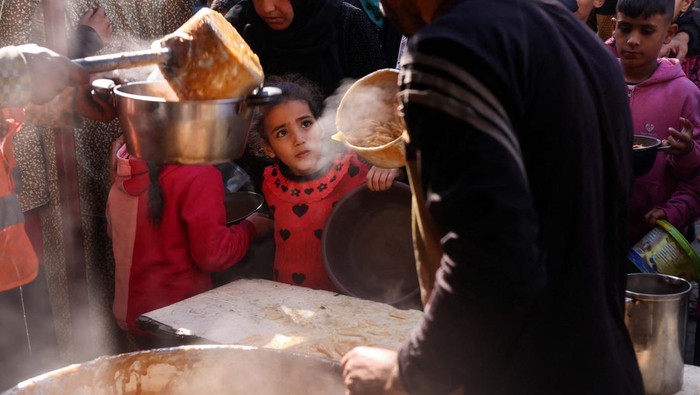 Palestinians wait to receive food cooked by a charity kitchen amid shortages of food supplies, amid the ongoing conflict between Israel and the Palestinian Islamist group Hamas, in Rafah in the southern Gaza Strip, January 16, 2024. REUTERS/Saleh Salem     TPX IMAGES OF THE DAY