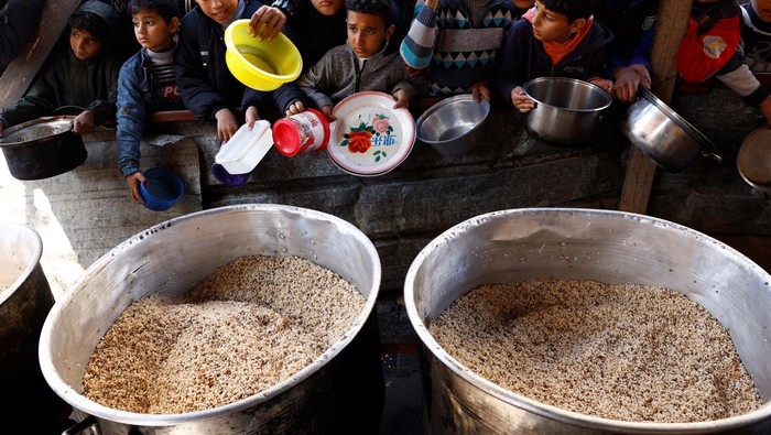 Ekspresi Anak-anak Gaza Saat Antre Makanan Palestinians wait to receive food cooked by a charity kitchen amid shortages of food supplies, amid the ongoing conflict between Israel and the Palestinian Islamist group Hamas, in Rafah in the southern Gaza Strip, January 16, 2024. REUTERS/Saleh Salem TPX IMAGES OF THE DAY