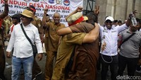 Para perangkat desa juga saling berpelukan.