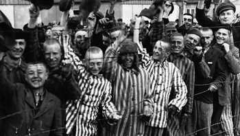 Tahanan di Kamp Konsentrasi Dachau Menyapa Pembebas Amerika Mereka Dari Pagar Kawat Berduri.(Jerman, April 1945) Foto: Reddit via Boredpanda