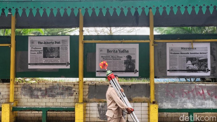 Isu Pelanggaran HAM Masa Lalu Hantui Dinding-dinding Jakarta Warga melintas di depan fotokopi kliping koran tahun 98 terkait kasus pelanggaran HAM yang dipasang di halte dan jalur pedestrian, Jl Rasuna Said, Jakarta, Selasa (6/2/2024).