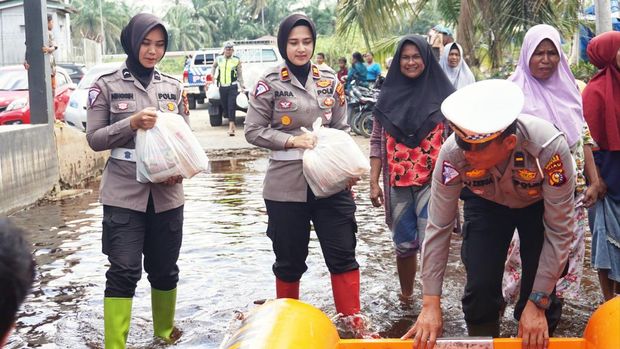 Kasat Lantas Polres Rohil Iptu Zahratul Aulia Harun saat mendistribusikan bantuan untuk masyarakat korban banjir. (Dok Polres Rohil)