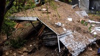 Sebuah mobil tertimbun reruntuhan bangunan yang roboh akibat longsor.