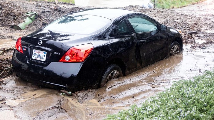 Rain falls as a car is stuck by a mudslide, caused by an ongoing rain storm in Studio City, California, U.S., February 5, 2024.  REUTERS/Aude Guerrucci