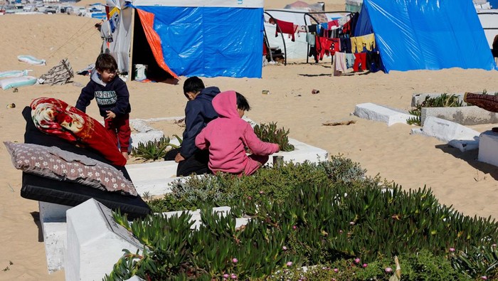 Pemakaman di Rafah Jadi Lokasi Pengungsian Displaced Palestinians, who fled their houses due to Israeli strikes, shelter in a cemetery, amid the ongoing conflict between Israel and Hamas, in Rafah in the southern Gaza Strip, February 5, 2024. REUTERS/Mohammed Salem